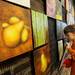  9-year-old Ann Arbor resident Cooper Rogers, right, takes a painting done by his father, Chris Rogers, off the wall for purchase during the 30x30 show at the Ann Arbor Art Center. Angela J. Cesere | AnnArbor.com
