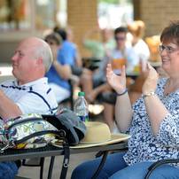 Susie Keat, who is the manager for musician Bill Edwards, right, claps with her husband, Bob Keat, after Bill Edwards sang a song during the AnnArbor.com Summer Concert Series on Friday afternoon. Angela J. Cesere | AnnArbor.com 