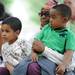 Detroit resident Deborah Mahdi holds her grandchildren Ebrahim Hasan, age 3, right, and Shuaib Taleb, age 4, left, while listening to a story at the 18th Juneteenth celebration in Wheeler Park. Angela J. Cesere | AnnArbor.com