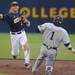 Michigan sophomore John DiLaura throws the ball to first base after tagging second to get out Coastal Carolina sophomore Jacob May. Angela J. Cesere | AnnArbor.com