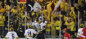 Michigan forward Chris Brown jumps up on the glass after scoring the first goal of the game against Miami of Ohio on his birthday. Fans cheered, holding up signs and Texas flags, which is where Brown is from. Angela J. Cesere | AnnArbor.com