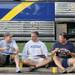 From left: Grosse Pointe resident John Hensien, White Lake resident Jon Georgian and Utica resident Brian Graham eat food on the curb in front of a giant bus before the Michigan football game against Notre Dame on Sept. 10, 2011. Angela J. Cesere | AnnArbor.com