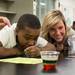 Washtenaw Community College student Claire Myers demonstrates to Mekhi Esters how liquids can have different densities during a trip a group of fourth-graders form Willow Run Community Schools March 20. Courtney Sacco I AnnArbor.com   