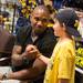 Former Wolverines football player Charles Woodson shakes hands with a young fan during the Mott Takeover telethon on WTKA at the MDen Friday May 17.
Courtney Sacco I AnnArbor.com