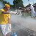 A volunteer sprays butter on to the chickens cooking over charcoal pits during the 60th Manchester Chicken Broil.  
Courtney Sacco I AnnArbor.com 