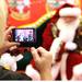 A woman takes a photo of a boy and Santa Claus as Santa's bus tour stopped in at the Macy's in Briarwood Mall Tuesday  December 6, 201. The purpose of the bus tour is to raise awareness of Macy's Believe campaign, which benefit?s Make-A-Wish.  Jeff Sainlar I AnnArbor.com
