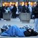 University of Michigan students Brian O'Connor, bottom, and Obaid Al Zaabi, top, sleep on the ground in sleeping bags by the Cube sculpture around 8am, waiting in line for tickets to watch President Barack Obama's speech at Al Glick Field House on Friday morning. Angela J. Cesere | AnnArbor.com
