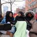 From left: U-M student Joyce Harris does homework on the sidewalk near the Michigan Union while waiting in line with friends Tonia Brown and Palesa Matinde. They arrived to wait in line at 1:00 am this morning to get tickets. Angela J. Cesere | AnnArbor.com
