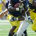 Eastern Michigan linebacker Marcus English takes down Michigan running back Vincent Smith during the football game at Michigan Stadium on Saturday. Angela J. Cesere | AnnArbor.com