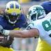 Eastern Michigan defensive lineman Brad Ohrman grabs onto junior quarterback Denard Robinson during the football game at Michigan Stadium on Saturday. Angela J. Cesere | AnnArbor.com