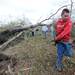 19-year-old University of Michigan student Ian McCarthy carries branches away from a fallen tree on the edge of Dennis Linder's property along Dexter-Pinckney road. McCarthy, along with other students who are part of a fashion company called Merit, came out to volunteer in the clean-up effort after a tornado stuck Dexter. Angela J. Cesere | AnnArbor.com
