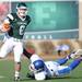 Eastern Michigan quarter back Alex Gillett, left, escapes the grasp of Buffalo defensive lineman Steven Means as he runs down the field. Angela J. Cesere | AnnArbor.com