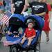 Carol Horn of Sidetrack Bar and Grill waves while pushing her sons, Dominick, age 2, right, and 4-month-old Patrick, during the Ypsilanti Fourth of July parade on Cross St. Angela J. Cesere | AnnArbor.com