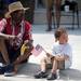 Scott Robinson, left, watches the Ypsilanti Fourth of July parade with his 2-year-old nephew, Antonio Robinson, on Cross St. Wednesday morning. Angela J. Cesere | AnnArbor.com