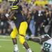 Junior quarterback Denard Robinson looks for a pass while defensive end Kapron Lewis-Moore hangs onto his shirt during the football game against Notre Dame on Sept. 10, 2011. Angela J. Cesere | AnnArbor.com