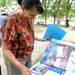 Ypsilanti resident Regina Hunter looks through an Ann Arbor NAACP photo album during the Juneteenth celebration at Wheeler Park. Angela J. Cesere | AnnArbor.com