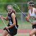 Huron's Taylor Standiford, right, runs after Pioneer's Stephanie Terrell during the lacrosse quarter finals game at South Lyon High School. Angela J. Cesere | AnnArbor.com