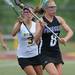 Huron's Kelsey Gradwohl, left, tries to knock the ball out of the net of Pioneer's Caroline Hurd during the lacrosse quarter finals game at South Lyon High School. Angela J. Cesere | AnnArbor.com