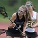 Pioneer's Samantha Zwolan, left, tries to avoid Huron's Barbara Runstadier as she moves toward the goal during the lacrosse quarter finals game at South Lyon High School. Angela J. Cesere | AnnArbor.com
