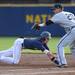Michigan freshman Will Drake dives back to the bag as Coastal Carolina junior Sloan Gilliam reaches for the ball. Angela J. Cesere | AnnArbor.com