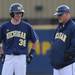 Michigan freshman Dylan Delaney chats with assistant coach Matt Husted on first base during a break in the game against Coastal Carolina. Angela J. Cesere | AnnArbor.com