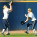Michigan left fielder Nicole Sappingfield, left, catches a fly ball as center fielder Bree Evans backs her up. Angela J. Cesere | AnnArbor.com
