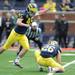 Michigan junior wide receiver Drew Dileo holds the ball for sophomore kicker Matt Wile while he attempts a extra point after a touchdown.  Angela J. Cesere | AnnArbor.com
