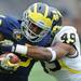 Michigan redshirt freshman running back Justice Hayes tries to break free of the grip of freshman linebacker Kaleb Ringer. Angela J. Cesere | AnnArbor.com

