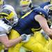 Michigan sophomore quarter back Alex Swieca, right, struggles against the grip of sophomore defensive end Chris Rock. Angela J. Cesere | AnnArbor.com
