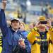 Toledo resident Dale Mehring, left, cheers while Fenton resident Jeff Anderson takes a photo as the football team comes off the field at the end of the spring game. Angela J. Cesere | AnnArbor.com

