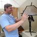 Artist Luke Proctor adjusts a lamp shade on his lamps, created through blacksmithing, at the Ann Arbor Street Art Fair on N. University. Angela J. Cesere | AnnArbor.com 