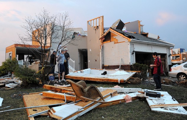 People move belongings out of a house on the corner of Meadow View and York St. in Dexter after a tornado struck their home. Angela J. Cesere | AnnArbor.com