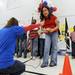 6th grade teacher Rebeca Hypnar, left, holds the microphone for 6th grader Jessica Doernte as she reads off a few words of thanks to veterans during the ceremony. Angela J. Cesere | AnnArbor.com