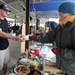 Mary Wessel Walker, right, owner of Harvest Kitchen, hands a bowl of vegetarian thai curry soup to Ann Arbor resident John Donnell. Angela J. Cesere | AnnArbor.com