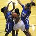 Ypsilanti's Carneysha McGee, center, looks for a pass around Ypsilanti Lincoln's Asia Youngblood, left, and Katelyn Morris. Angela J. Cesere