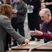 Precinct election inspector Alan Connor checks the identification of a voter Tuesday morning at Forsythe Middle School. Melanie Maxwell I AnnArbor.com