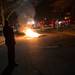 An Ann Arbor police officer watches as debris burns in the middle of Church Street in Ann Arbor after the Wolverines' loss to Louisville.
 Courtney Sacco I AnnArbor.com