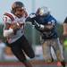 Belleville's quarterback Luke Edwards dodges a tackle  Lincoln's L.T. Bolden during the second quarter of their game at Lincoln High School, Friday, Aug, 30.
Courtney Sacco I AnnArbor.com    