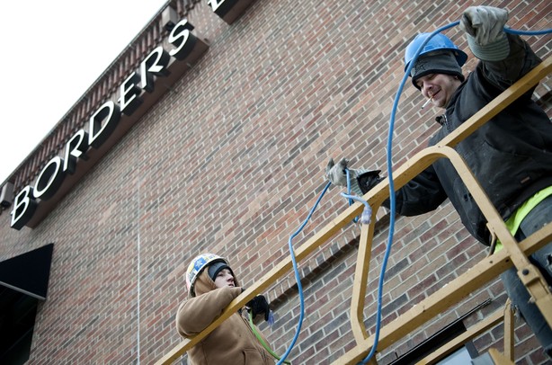 Foreman Shaun Michaels and Laborer Zach Dillinger organize extension cords on top of a scissor lift before removing the Borders sign on Liberty Street on Monday Dec. 31. Daniel Brenner I AnnArbor.com