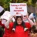 Megan Geniesse is helped by Keeley Wackler,3, to convey their message. Over 400 nurses and supporters showed up to take part in the rally at Liberty Plaza downtown to march to the University of Michigan Hospital and protest Wednesday October, 12, 2011. Jeff Sainlar I AnnArbor.com