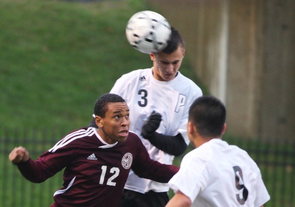 Pioneer's Josh Graves heads it over Dante Violette as Pioneer High School took on University of Detroit Jesuit  at Saline High School Wednesday October 26, 2011. Pioneer won the game 5-1 to advance to the next round. Jeff Sainlar I AnnArbor.com