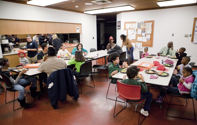 Families enjoy a meal from Cottage Inn while the Ann Arbor Fire Department hosted its annual Bikes for Tykes event Tuesday December 13, 2011. The AAFD and Two Wheel Tango, a local bike shop, team up to provide bikes and helmets for children ages 4 to 10 who need assistance during the holiday season. Jeff Sainlar I AnnArbor.com