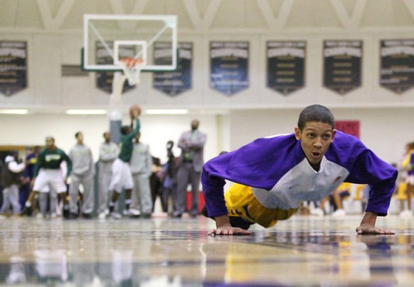 Ypsilanti's Janeau Joubert warms up with some diving on the floor exercises before Ann Arbor Huron took on Ypsilanti  at Huron High School Friday December 16, 2011. Ypsilanti won the game 66-57. Jeff Sainlar I AnnArbor.com